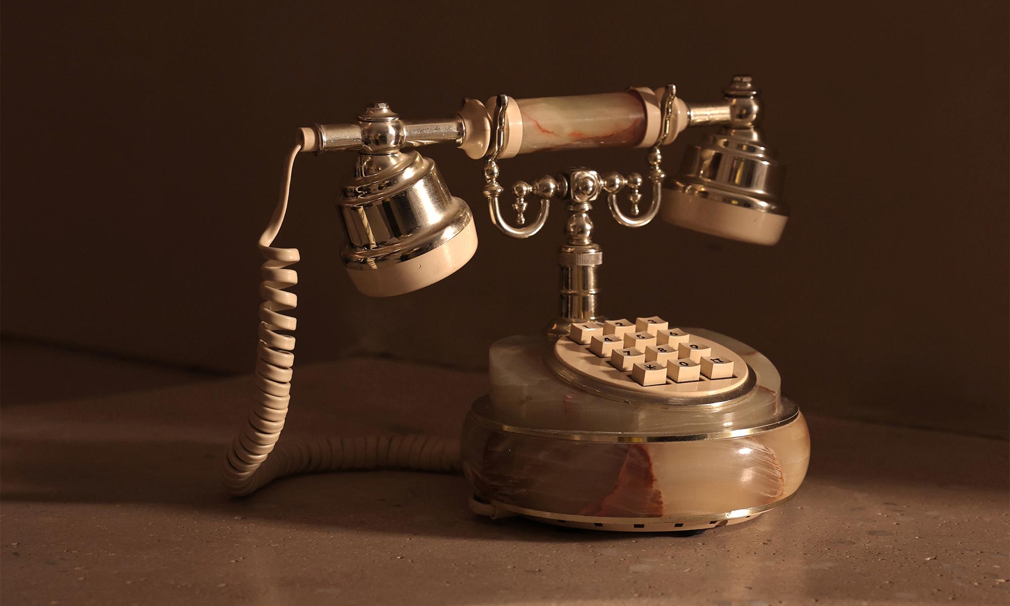 Un téléphone rétro avec cadran à touche, en onyx et dorure.